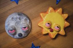 two clay animals sitting next to each other on top of a wooden table with blue stars