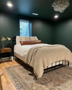 a bed sitting on top of a wooden floor next to a window in a bedroom