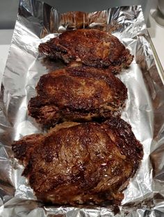 three pieces of meat sitting on top of aluminum foil