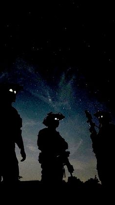 three people standing in the dark with their helmets on