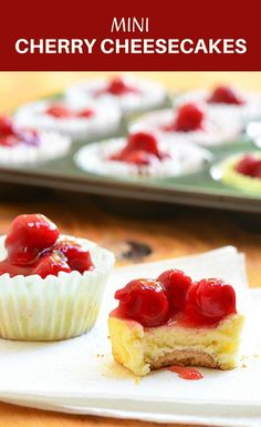 two small desserts with cherries on them are sitting on a white paper napkin