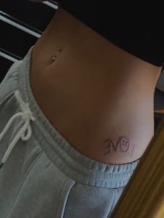 a woman's stomach with the word love tattooed on her lower back and side