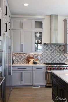 a kitchen with white cabinets and stainless steel appliances