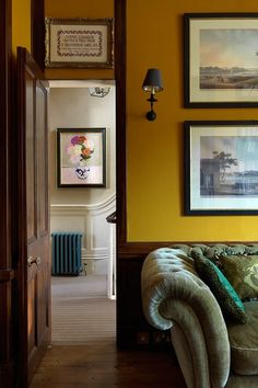 an open door leading to a living room with pictures on the wall and paintings above it