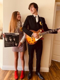 two people are dressed up as musicians and one is holding an electric guitar