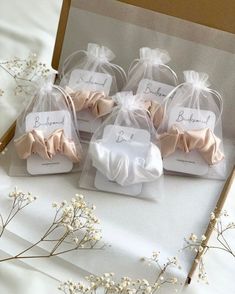 four small favors are wrapped in organ - ribbon and tied with twine bow ties