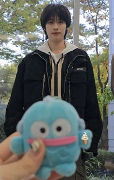 a person holding a small stuffed animal in their hand