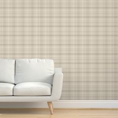 a couch sitting in front of a wall with a checkered pattern on the wall