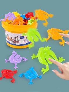 children's hand reaching for plastic frog toys in a bucket with the words physical bounce requires no