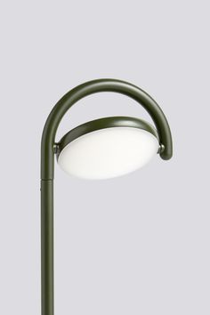 a green lamp with a white light on the top and bottom part of it's arm