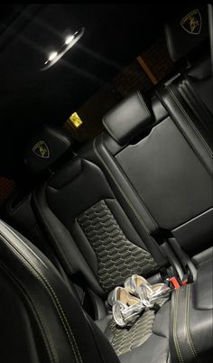 the interior of a car with black leather seats and yellow stitching on the floor