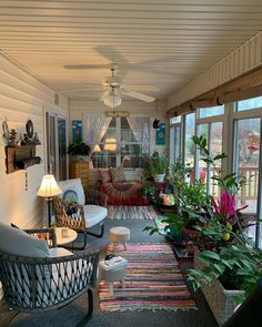 a living room filled with lots of furniture and plants on top of it's windows