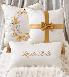 three pillows with bows and ribbons on them