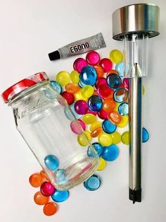 a jar filled with jelly beans next to a metal pipe and some confetti