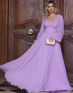 a woman in a long purple dress standing next to a wooden door with her hand on her hip