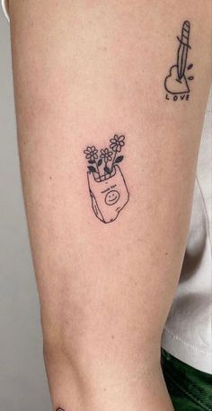 a woman's arm with a tattoo on it and a flower pot in the middle