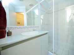 a bathroom with a shower, sink and mirror