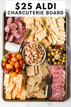 an assortment of cheeses, crackers, olives and meats in a tray