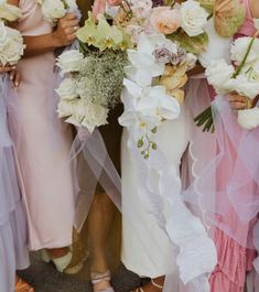 the bridesmaids are holding their bouquets together