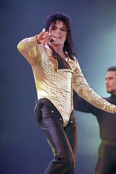 michael jackson performing on stage with his hands in the air and one hand up to his face