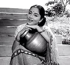 an old photo of a woman holding a pot