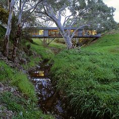 the house is built on top of a hill and has a river running through it