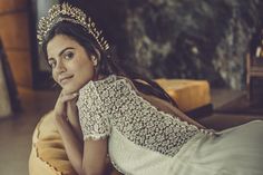 a woman wearing a tiara laying on a pillow