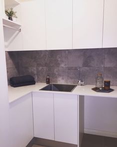 a kitchen with white cabinets and a black sink