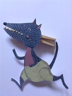 an animal made out of paper with a wooden stick in its mouth