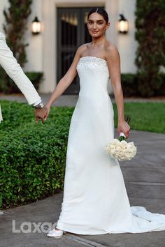 the bride and groom are holding hands