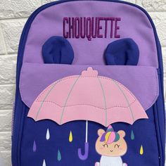 a purple backpack with a pink umbrella on the front and an image of a teddy bear under it