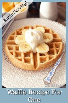 a waffle topped with bananas and whipped cream on a plate next to oranges