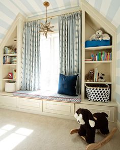 a child's bedroom with blue and white striped walls, built - in bookshelves and toys