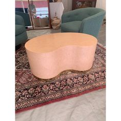 an oval shaped coffee table on top of a rug