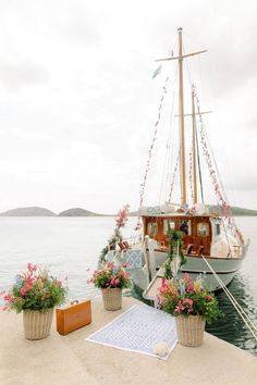 there is a boat that is docked at the water's edge with flowers on it