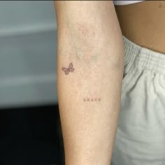 a close up of a person's arm with a small tattoo on it that says grace