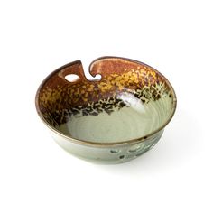 a brown and green bowl on a white background