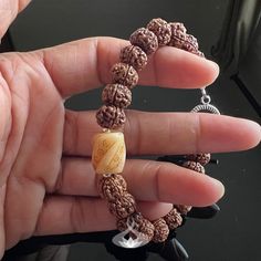 Calm your body and mind with this handmade Rudraksha Mala bracelet. Made with 5 Muhki Rudraksha beads and a carved Tibetan Yak Bone focal bead. This beaded bracelet was designed as a powerful spiritual accessory, filled with positive energy.  Rudraksha seeds are said to safeguard the wearer from negative energies and can help with clarity of body, mind, and thought for enhanced consciousness. Their calming effects are often used to help reduce blood pressure and overall health.  SPIRITUAL PROPERTIES OF THE BRACELET Good Luck, Prosperity, and Abundance. Purification and Cleansing. Concentration and Emotional Balance. Peace, Tranquility and Calmness About * Handmade Bracelet  * 5 Mukhi Rudraksha Bracelet * Select Your Size * Available with 10 mm Rudraksha Seeds * Carved bone barrel bead meas Spiritual Polished Beads Bracelets For Meditation, Spiritual Bracelets With Polished Beads For Meditation, Adjustable Polished Beads Bracelets For Meditation, Handmade Holistic Bracelets With Round Beads, Adjustable Mala With Polished Beads For Healing, Adjustable Artisan Mala As A Gift, Spiritual Brown Stretch Bracelet With 8mm Beads, Hand-strung Brown Beaded Bracelets For Meditation, Brown Hand-strung Beaded Bracelets For Meditation