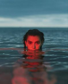 a woman is submerged in the water with her head above the water's surface