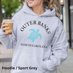 Everyone needs a cozy go-to hoodie to curl up in, so go for one that's soft, smooth, and stylish. It's the perfect choice for cooler evenings! * 50% pre-shrunk cotton, 50% polyester * Fabric weight: 8.0 oz/yd² (271.25 g/m²) * Air-jet spun yarn with a soft feel and reduced pilling * Double-lined hood with matching drawcord * Quarter-turned body to avoid crease down the middle * 1 × 1 athletic rib-knit cuffs and waistband with spandex * Front pouch pocket * Double-needle stitched collar, shoulders, armholes, cuffs, and hem This product is made especially for you as soon as you place an order, which is why it takes us a bit longer to deliver it to you. Making products on demand instead of in bulk helps reduce overproduction, so thank you for making thoughtful purchasing decisions! Outer Banks Hoodie, Outer Banks Sweatshirt, Outer Banks North Carolina, Outer Banks Nc, Outer Banks, Knit Cuff, Pocket Pouch, Banks, North Carolina