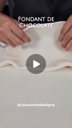 a person is cutting fabric with scissors on a white tablecloth that has chocolate in it