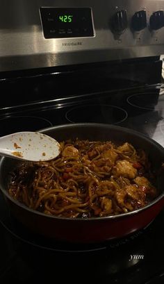 a pan filled with food sitting on top of a stove next to an oven door