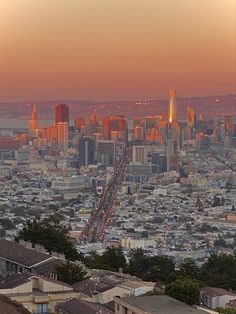 the city skyline is lit up at sunset