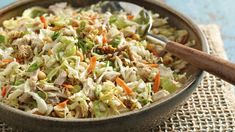 a bowl filled with coleslaw and carrots on top of a cloth covered table