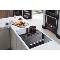 a kitchen with an oven, stove and cutting board on the counter top in front of it