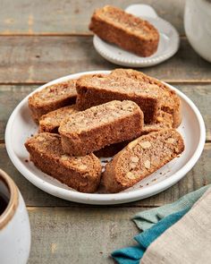 several pieces of bread on a plate next to a cup of coffee and saucer