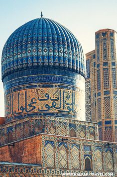 an ornate blue and gold dome on top of a building with two smaller buildings in the background