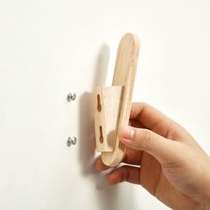 a person is holding a wooden object on the wall