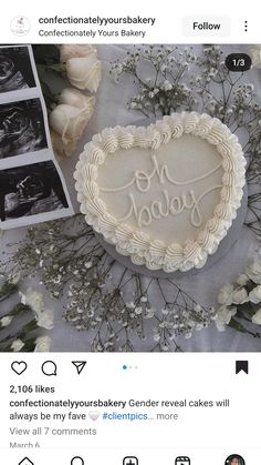 a cake with the word baby written on it next to some flowers and photos in front of them