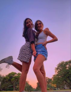 two girls are posing for the camera on a skateboard